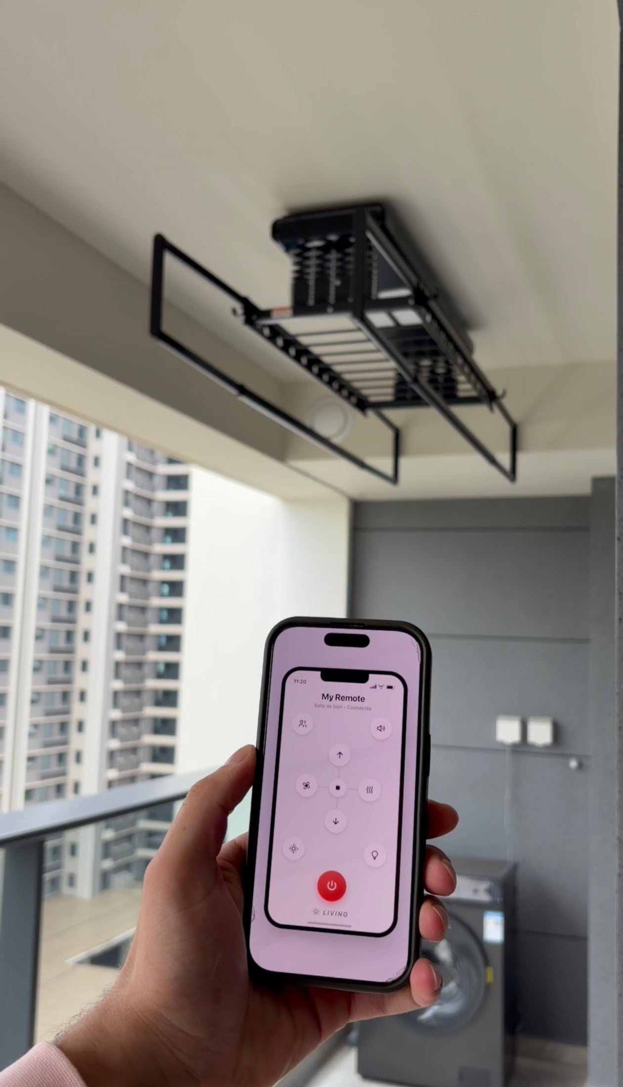 Hand holding a phone running the app that controls the SkyLift rack